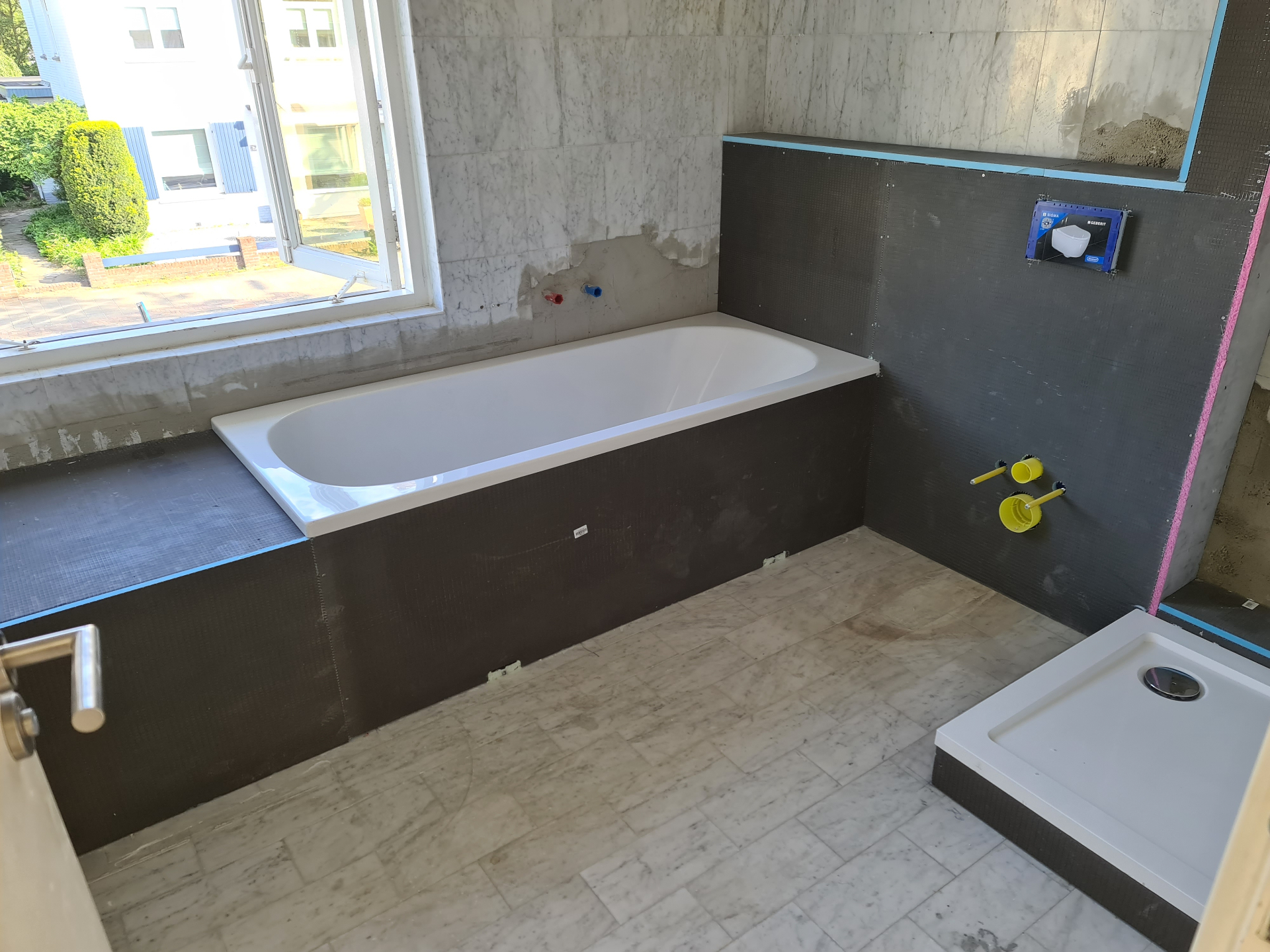 Badkamer renovatie met ligbad en douchehoek